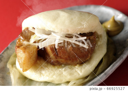 レタスが敷いてあるお皿に置かれた白髪ねぎも一緒に挟まった蒸したてで湯気上がる熱々な角煮まんと和がらし 66925527