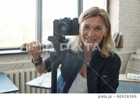 Mature lady photographer enjoying photo shoot 66926369