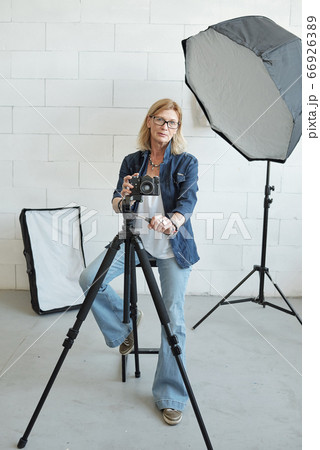 Photographer adjusting camera on tripod 66926389