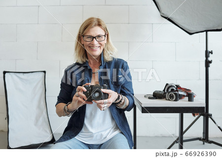 Cheerful photographer using camera Cheerful photographer using camera 66926390