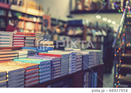 lot of new books in hardcover. image of Abstract Blur people at book store in shopping mall for background usage. toned 66927958
