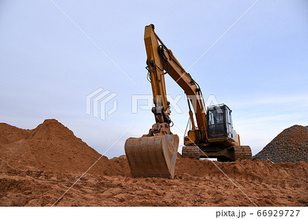 Track-type excavator during earthmoving works at open-pit mining 66929727