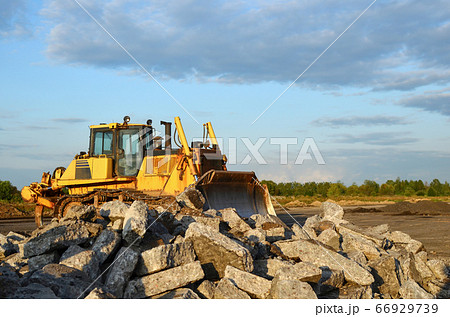 Bulldozer with bucket for pool excavation and utility trenching. Dozer during demolition concrete 66929739