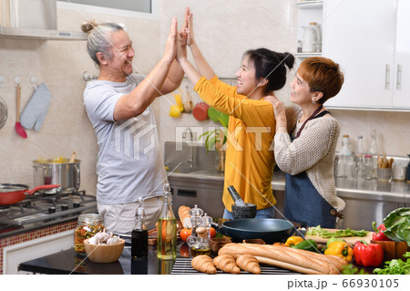 Happy family of mother father and daughter cooking in kitchen 66930105