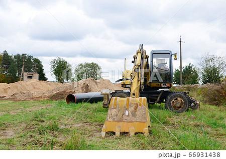 Excavator digs ground for the installation of industrial gas and oil pipes Excavator digs ground for the installation of industrial gas and oil pipes 66931438