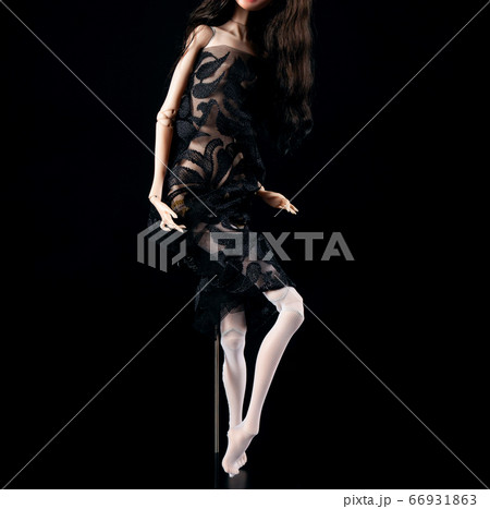 Plastic doll in a beautiful transparent dress on a black background Plastic doll in a beautiful transparent dress on a black background 66931863