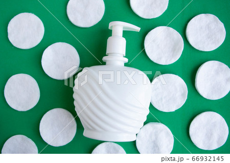 Cotton sponges and cosmetic bottle on green background, top view Cotton sponges and cosmetic bottle on green background, top view 66932145