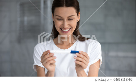 Happy young woman excited with positive pregnancy test result Happy young woman excited with positive pregnancy test result 66933846