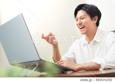 ノートPCの画面を見る笑顔の男性 66934260