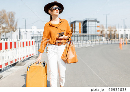 Woman with a suitcase on the city street 66935833