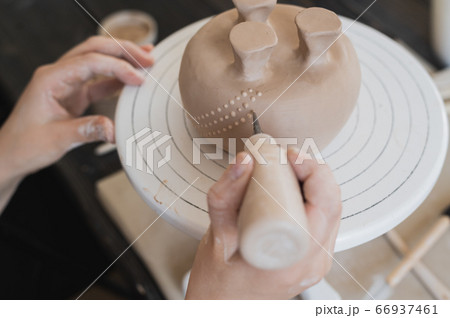 Child in the process of decorating the clay vase. Children pottery studio. Child in the process of decorating the clay vase. Children pottery studio. 66937461