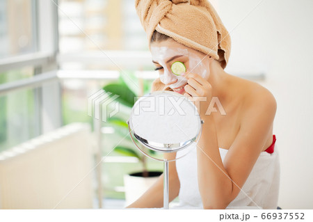 Skin care, young woman with beautiful facial skin applying mask on face Skin care, young woman with beautiful facial skin applying mask on face 66937552
