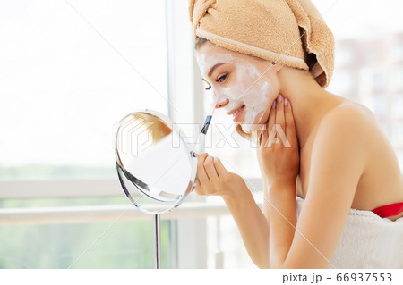 Skin care, young woman with beautiful facial skin applying mask on face 66937553