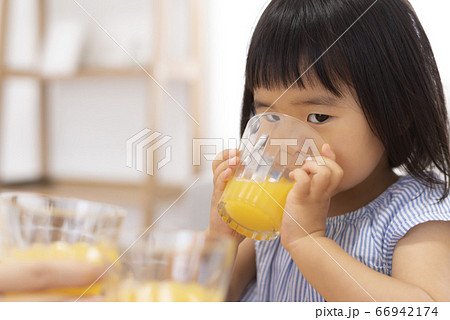 オレンジジュースで乾杯する子供 66942174