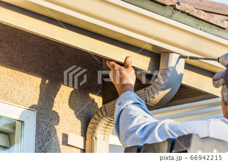 Worker Attaching Aluminum Rain Gutter and Down Spout 66942215