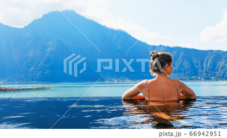 Happy woman relaxing in Batur volcano hot spring 66942951
