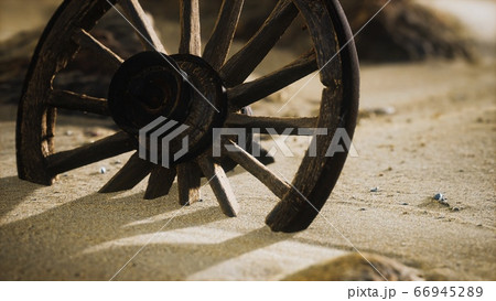 Large wooden wheel in the sand Large wooden wheel in the sand 66945289