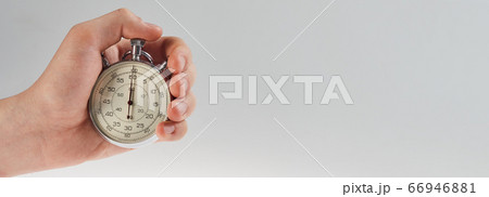 hand holding a stopwatch on a gray background 66946881