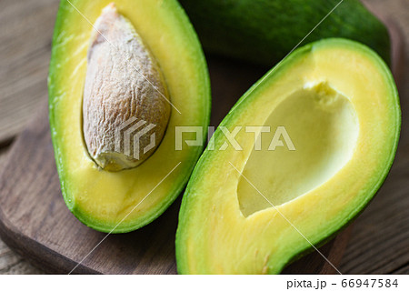 Chopped Avocados In A Bowl On Cutting Board On Wooden Background. Half  Avocado With Pulp And Seed, Whole Green Fresh Tropical Fruit On Brown  Table, Top View Stock Photo, Picture and Royalty