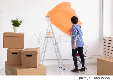 Renovation, redecoration and repair concept - middle-aged woman painting wall in new home. 66949590