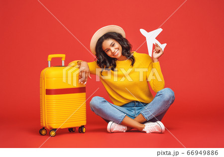 Positive ethnic tourist with toy plane 66949886