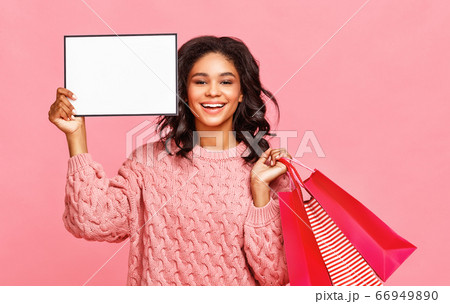 Happy ethnic shopper with empty placard. 66949890