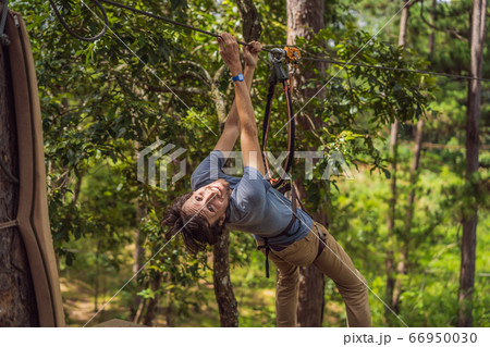 Young attractive man in adventure rope park in safety equipment 66950030