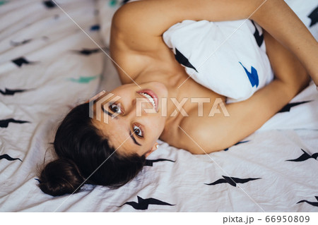 Beautiful young girl is sleeping. She is waking up and smiling. 66950809