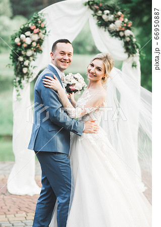 Romantic wedding moment, couple of newlyweds smiling portrait, bride and groom hugging 66950887