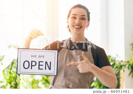 business owner holding the sign for the reopening 66951481