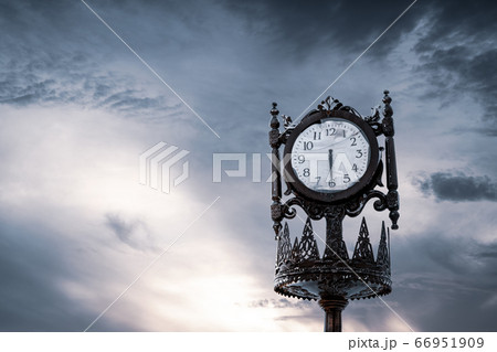 Vintage analogue clock against sunset with beautiful clouds. Vintage analogue clock against sunset with beautiful clouds. 66951909