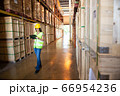 Caucasian female warehouse worker checking the 66954236
