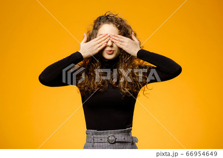 Pretty girl with curly hair on yellow background 66954649