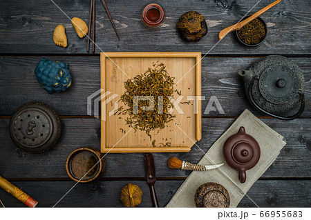 Chinese tea on square light board with different tea tools and figurines on black wooden table. View from above 66955683