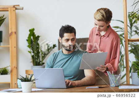 Female Manager Showing Documents to Colleague Female Manager Showing Documents to Colleague 66956522