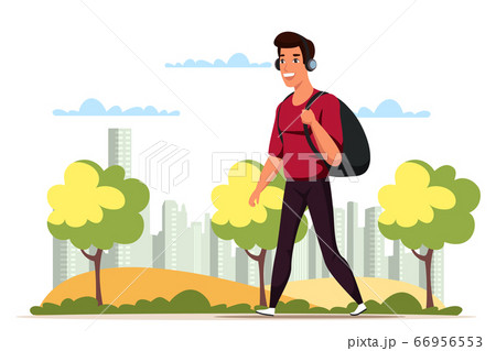 Man in headphones walking with backpack in park 66956553