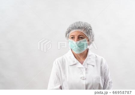 Tired female medic, nurse in protective equipment and a mask from viruses, on a white background. Tired female medic, nurse in protective equipment and a mask from viruses, on a white background. 66958787