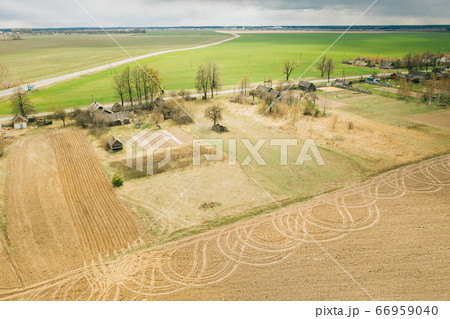 Belarus. Aerial View Of Belarusian Village. Beautiful Rural Landscape In Bird's-eye View. Beginning Of Agricultural Spring Season. Tracks On Plowed Field From Agricultural Machinery 66959040