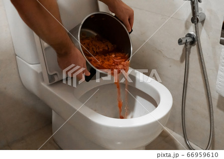 The girl pours a pot of soup into the toilet. The girl pours a pot of soup into the toilet. 66959610