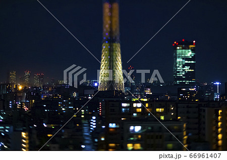 高層階から撮影したミニチュア風の東京スカイツリーと周辺の夜景の写真素材