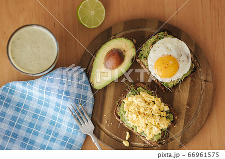 Different cooked egg on avocado sandwich with whole grain bread on wooden board. Top view 66961575