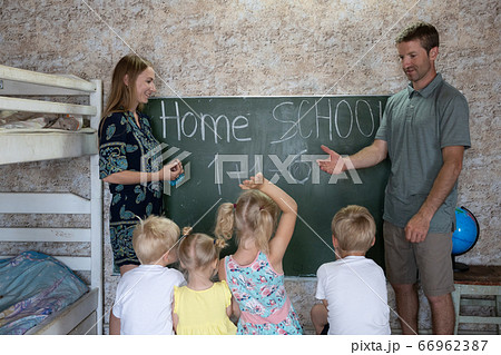 Parents teach their children at the blackboard in their home. Home school. Parents teach their children at the blackboard in their home. Home school. 66962387