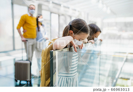 Family with two children going on holiday, wearing face masks at the airport. 66963013
