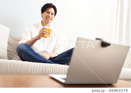 PCの画面を見ながら酒を飲む男性 PCの画面を見ながら酒を飲む男性 66963579