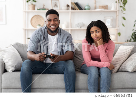 Boring Date. Excited Black Guy Playing Video Games And Ignoring Girlfriend Next To Him Boring Date. Excited Black Guy Playing Video Games And Ignoring Girlfriend Next To Him 66963701