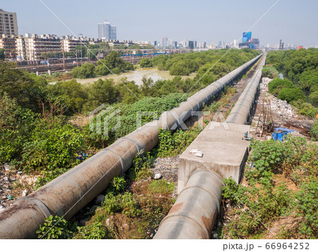 Mumbai, India - December 17, 2019: A thick pipe in a poor area of Mumbai. Mumbai, India - December 17, 2019: A thick pipe in a poor area of Mumbai. 66964252