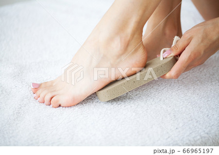 Woman cleans the heel of the foot with pumice Woman cleans the heel of the foot with pumice 66965197