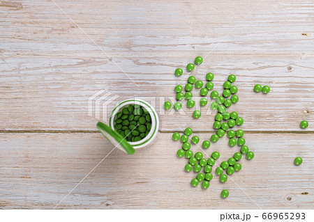 Home therapy. Round green vitamin pills on wooden table 66965293