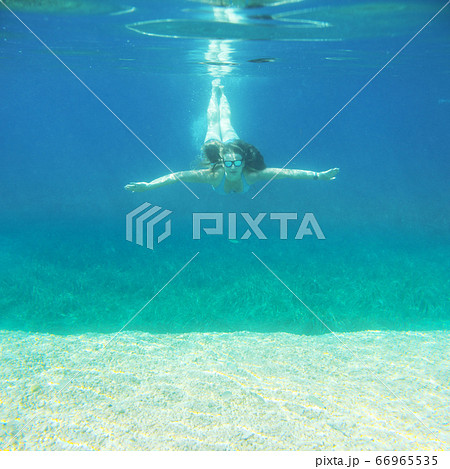 Woman swimming underwater Woman swimming underwater 66965535