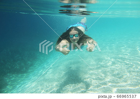 Woman swimming underwater Woman swimming underwater 66965537